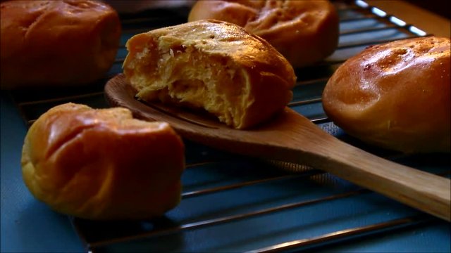 Tilting video shot of freshly baked Filipino delicacy called Pan de Coco or bread roll with sweetened coconut filling