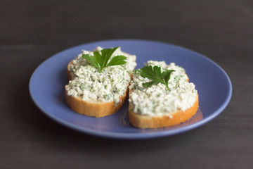 sandwiches with cottage cheese and herbs on a dark background, healthy and low-calorie snack between main meals