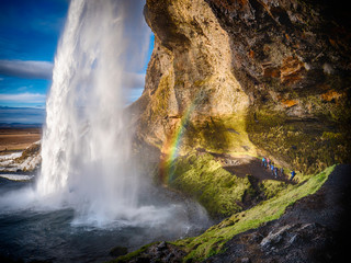 Seljalandsfoss, a majestic and powerful waterfall in Iceland in a sunny spring day with a raibow