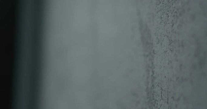 Slow motion shot of decorative dark concrete surface, shot handheld