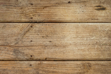 Background of weathered wooden planks with nails and streaks. Texture of old and big wooden boards of light brown colors.