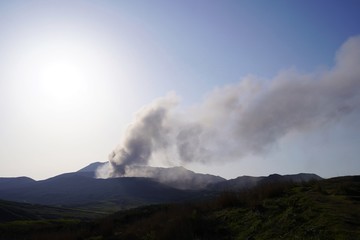 煙を吐く阿蘇火山の風景