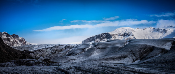 Obraz premium Huge majestic glacier's icy surface by snowy mountain in Iceland