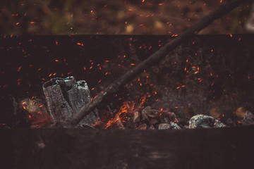 charcoal smolder in the iron grill. cooking picnic outdoors. sparks over the embers top view close up