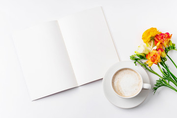 Flatlay with freesia flowers, capuccino cup and opened notebook on white background