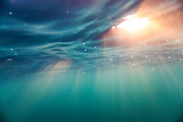 Bright beams of sunlight refracting through the surface of the atlantic ocean. - obrazy, fototapety, plakaty