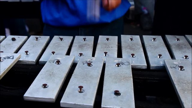 Close up video shot of hands of members of a marching band playing the lyre or xylophone