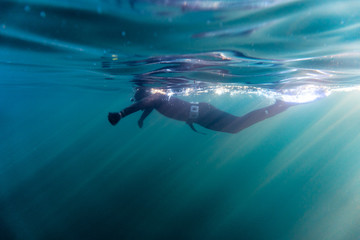 Freediver preparing for a dive in the blue cold atlantic on the shores of Norway.