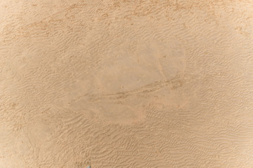 Fototapeta na wymiar Sandy beach with footprints seen from above.