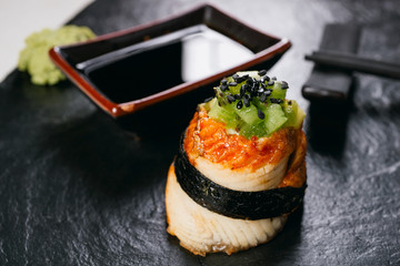 Eel sushi roll with kiwi, restaurant serving. Delicious seafood, delicacy, chef's menu, Japanese fusion food style