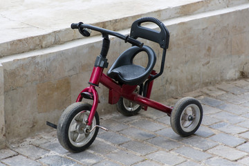 Fototapeta na wymiar old bike for children on the road of stones