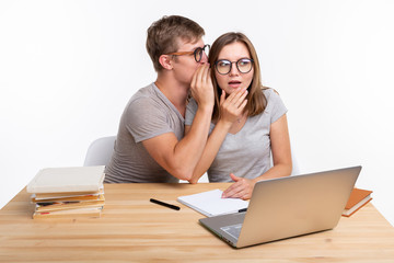 People and education concept - couple of students whispering