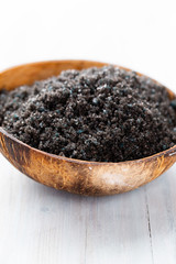 Sea salt in bowl, aroma oil in bottles, Wellness and flowers on grey textured background and flowers on vintage wooden background. Selective focus.