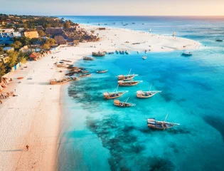 Papier Peint photo Zanzibar Vue aérienne des bateaux de pêche sur la côte de la mer tropicale avec plage de sable au coucher du soleil. Vacances d& 39 été sur l& 39 océan Indien, Zanzibar, Afrique. Paysage avec bateau, bâtiments, eau bleue transparente. Vue de dessus