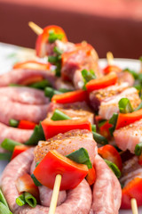 Close up pf delicious chicken breast on wooden skew with fresh vegetables, garlic, paprika fried on mangal barbeque grill and smoke