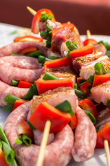 Close up pf delicious chicken breast on wooden skew with fresh vegetables, garlic, paprika fried on mangal barbeque grill and smoke