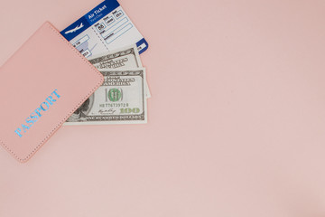 Passport, dollars and air ticket on a pink background. Travel concept, copy space