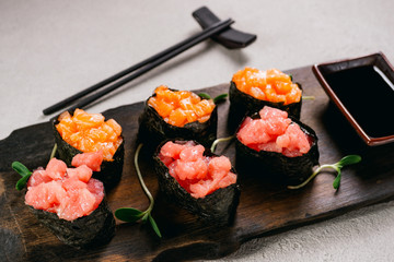 Seafood delicatessen gunkan maki sushi rolls on wooden plate. Different gourmet snacks. Luxury lifestyle, expensive food, restaurant menu
