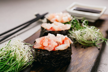 Seafood delicatessen gunkan maki sushi rolls on wooden plate. Deluxe restaurant menu. Luxury...