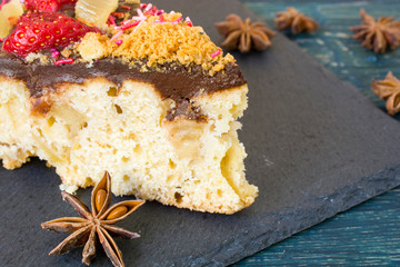 Homemade strawberry pie on the table. Chocolate glaze and rough wooden background.