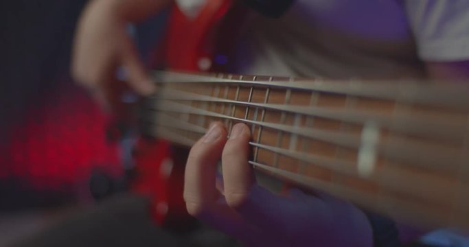 man playing bass guitar solo, fingers on bass fretboard