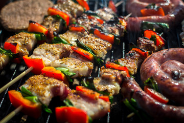 Close up pf delicious chicken breast on wooden skew with fresh vegetables, garlic, paprika fried on mangal barbeque grill and smoke