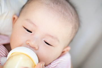 Asian baby happy in the room.Asian baby girl lying down on bed .