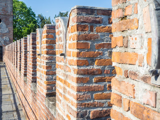 Urgnano, Bergamo, Italy. The medieval castle in the center of the village. Castle defensive wall with the battlements, merlons, crenels or crenellations of the wall and wall walk