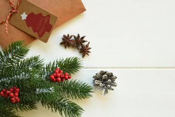 Christmas fir branches with decorations and gift on wooden white board. Toned image with copy space.