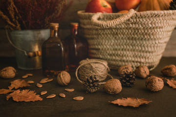 Colored fall vegenables on the vintage boards. Autumn decorations in wicker basket. A cornucopia with squash, gourds, pumpkins, cones, wheat and leaves. Toned image with copy space. Harvest time.