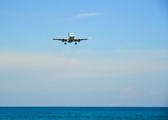 Fototapeta na wymiar Airplane landing over the sand beach