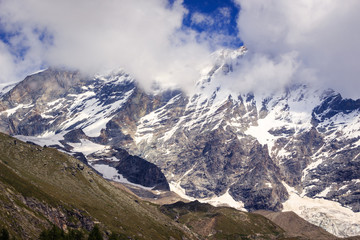 Fototapeta na wymiar Snow capped mountain peak in clouds