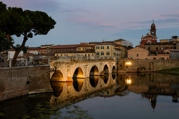 Obraz premium Famous place in Rimini, Italy. Tiberius Bridge, with evening lights.