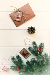 Christmas fir branches with decorations and gift on wooden white board. Toned image with copy space.