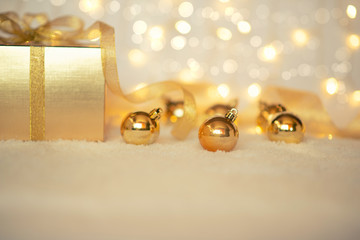 Christmas background with festive decoration. Merry Christmas and Happy New Year. Gold gift bos with ribbon, decoration on the blurred, sparking, glowing background. Copy space for your text.