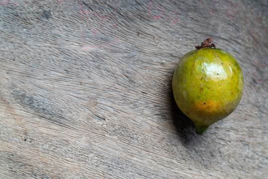 Close-up of exotic fruit Grugru nuts "Macauba" on wooden background. Original from a Brazilian native palm tree is used as food and its oil used in the production of biodiesel.