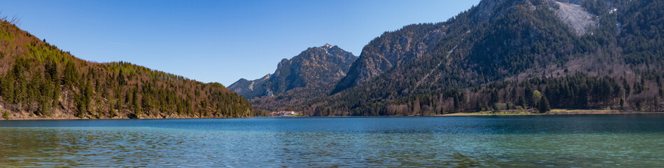 Traumhaftes Panorama des Alpsee mit dem Schloss Neuschwanstein zwischen den Bergen im Allgäu