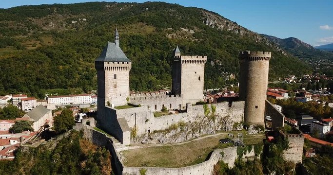 Aerial view of impressive medieval castle on rocky outcrop in French commune of Foix
