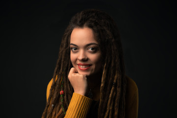 Portrait of a young girl with dreads on black background. Studio shoot.