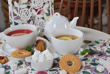 various cookies and biscuits baked at home in a container and tea in a retro cup with free space for text