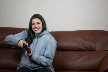 Beautiful brunette girl with dyed green hair with game console.