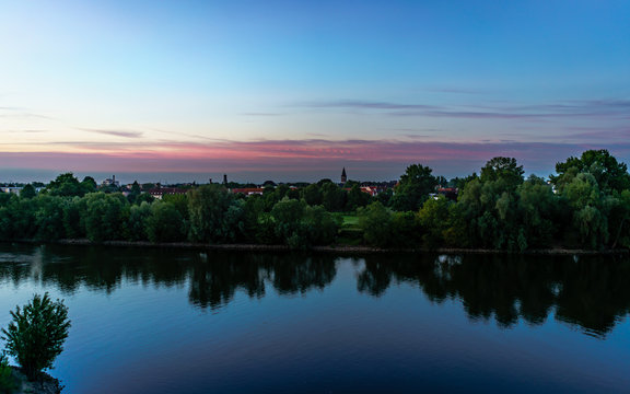 Landschaft mit Ort am Main im Sonnenaufgang