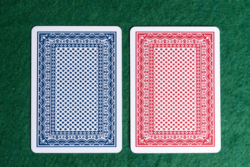 Back of the two playing cards. Red and blue color cards of the green table