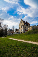 Fototapeta premium Germany, Fairy tale like fortress of lichtenstein behind green pasture and path at dawn