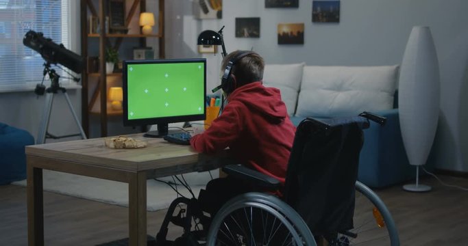 Wheelchaired boy using computer