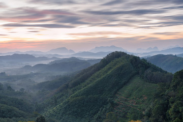 Beautiful sunrise scenery view in Phang Nga valley with view of fog flowing in the mountain valley in tropical rainforest, Southern of Thailand