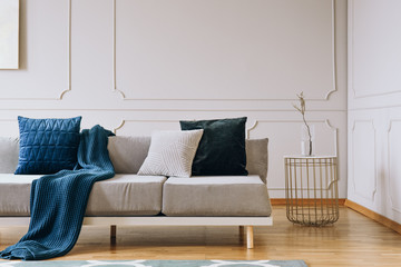 Blue blanket on grey couch in elegant living room interior