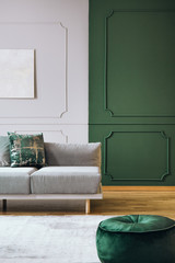 Green and grey wall with molding in chic living room interior with grey couch and wooden floor