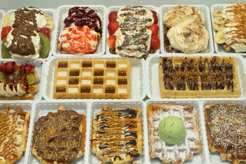 Fresh waffles with different fillings on the counter of the store