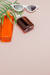 Bottle sunblock on bright square yellow and pink background. The concept of the resort at sea, summer time. Top view, flat lay, minimalism, copy space